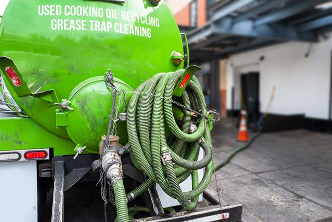 worker pumping grease trap at commercial kitchen in Beverly Shores